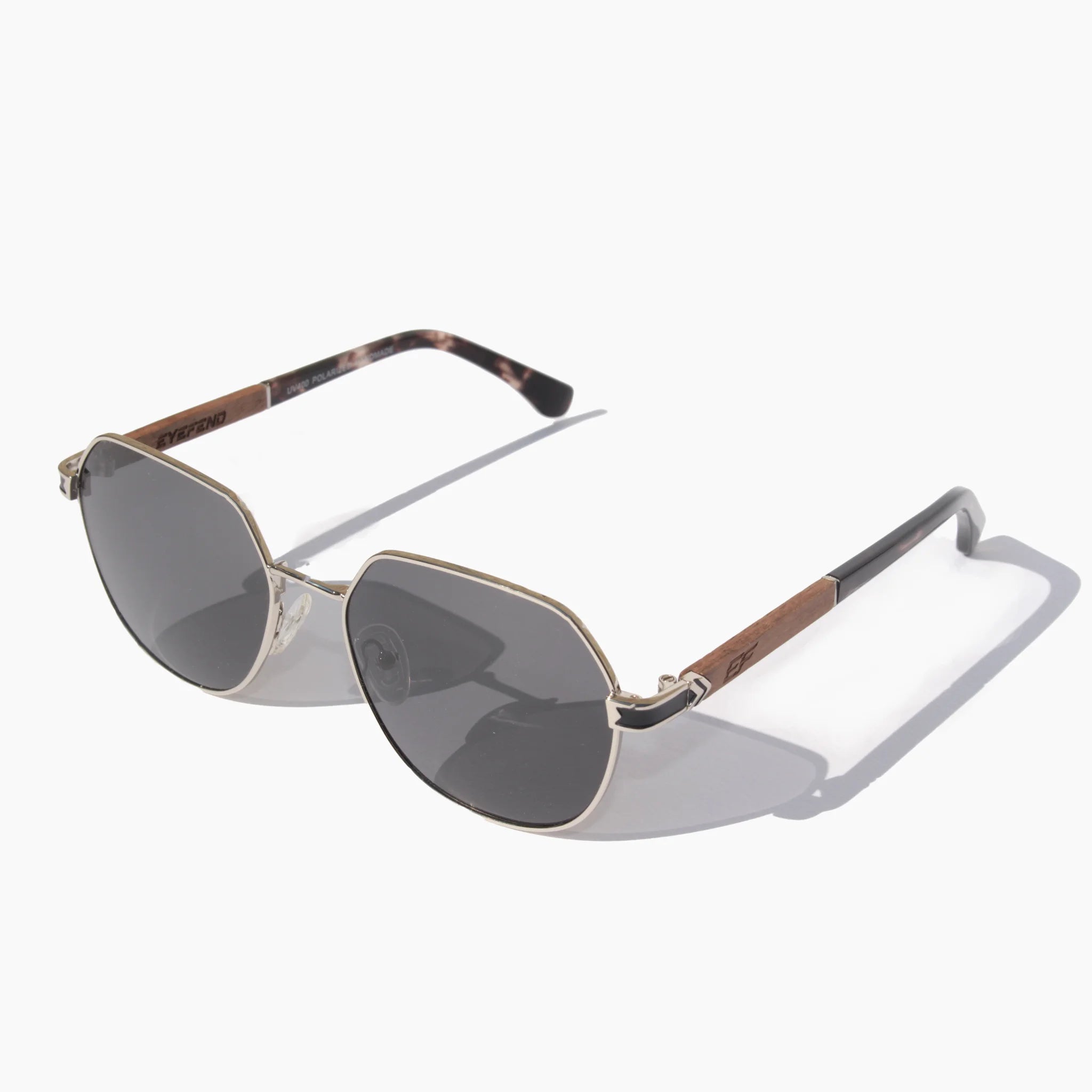 EyeFend Spark geometric aviator sunglasses featuring silver metal frames, dark grey polarized lenses, and textured wood-grain with acetate temple details