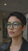 Woman wearing EyeFend green translucent photochromic blue light blocking glasses that darken in sunlight.